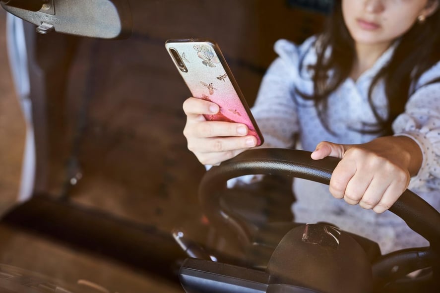 A woman driving while distracted by texting on her phone in Atlanta, Georgia