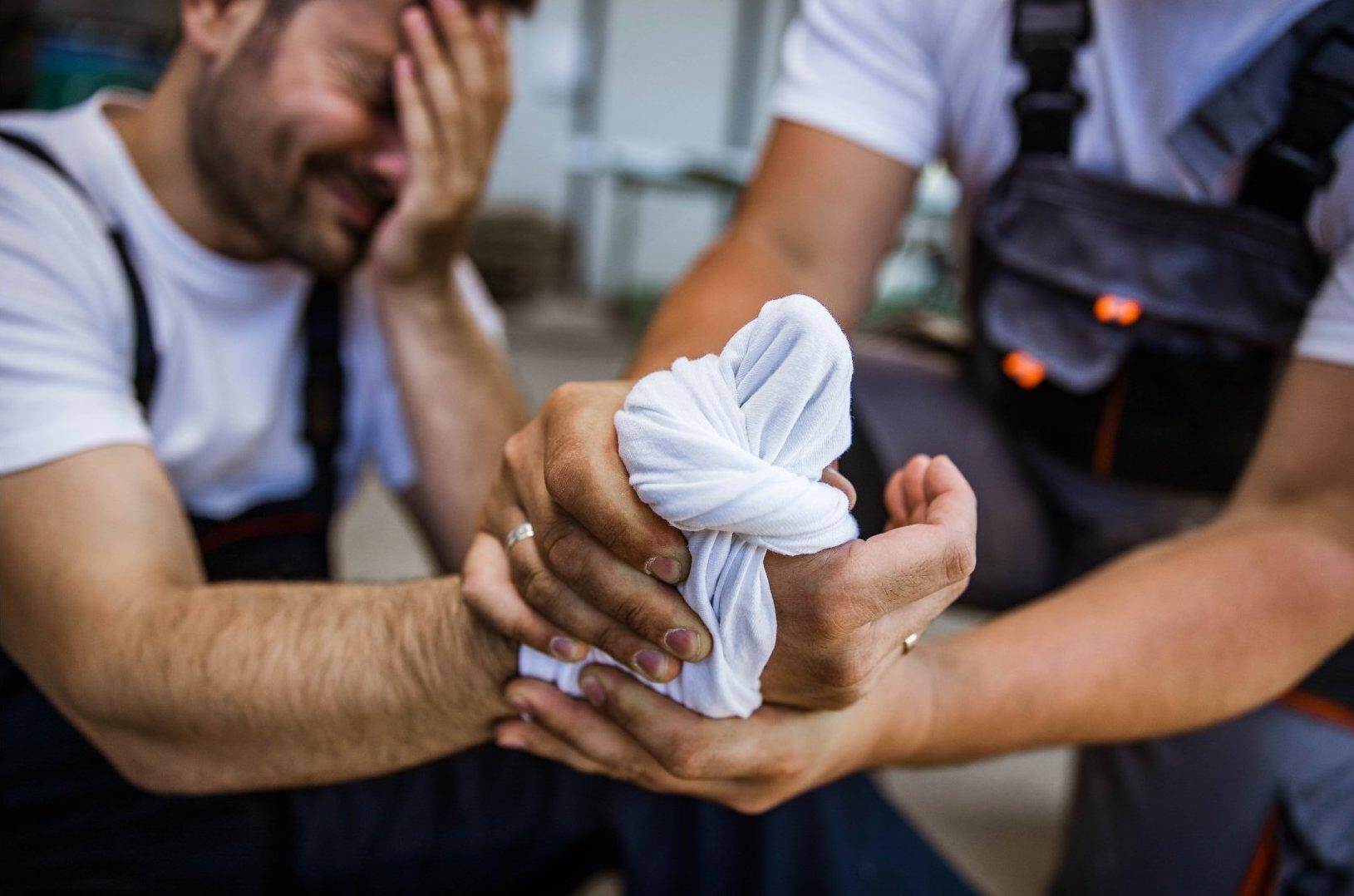 A male worker who has been injured on the job bandaging his hand in Americus, Georgia