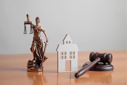 A statue of a woman holding a balance, a facade of a court house, and a gavel in Candler-McAfee