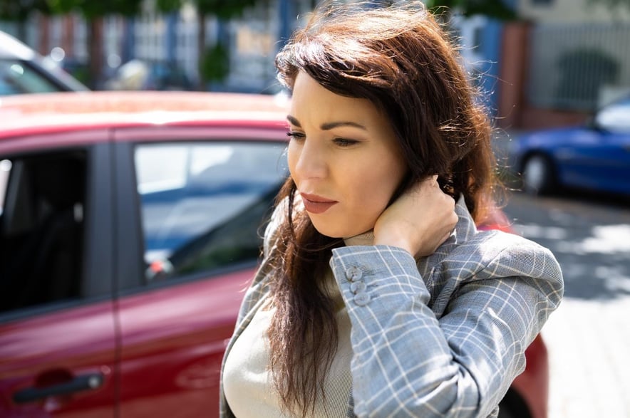 A young woman who rubbing her neck because she has whiplash after a car accident in Acworth, Georgia